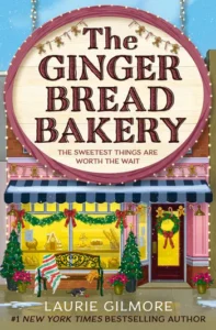 Book cover of The Gingerbread Bakery by Laurie Gilmore featuring a festive storefront decorated with Christmas wreaths, garlands, and holiday lights.