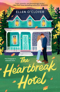 Book cover of The Heartbreak Hotel by Ellen O’Clover featuring an illustrated teal house with a porch, autumn trees in the background, and a couple standing close together in front of the house with fallen leaves around them.