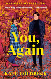 Book cover of You, Again by Kate Goldbeck featuring a man and woman standing in a New York City park with golden autumn leaves, highlighting its witty enemies-to-lovers romance.